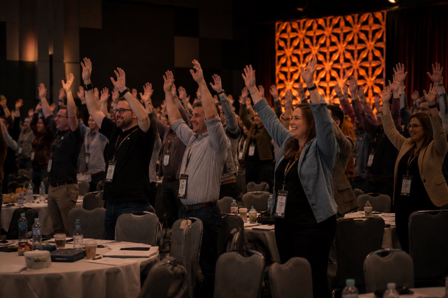 An engaged conference audience with hands raised